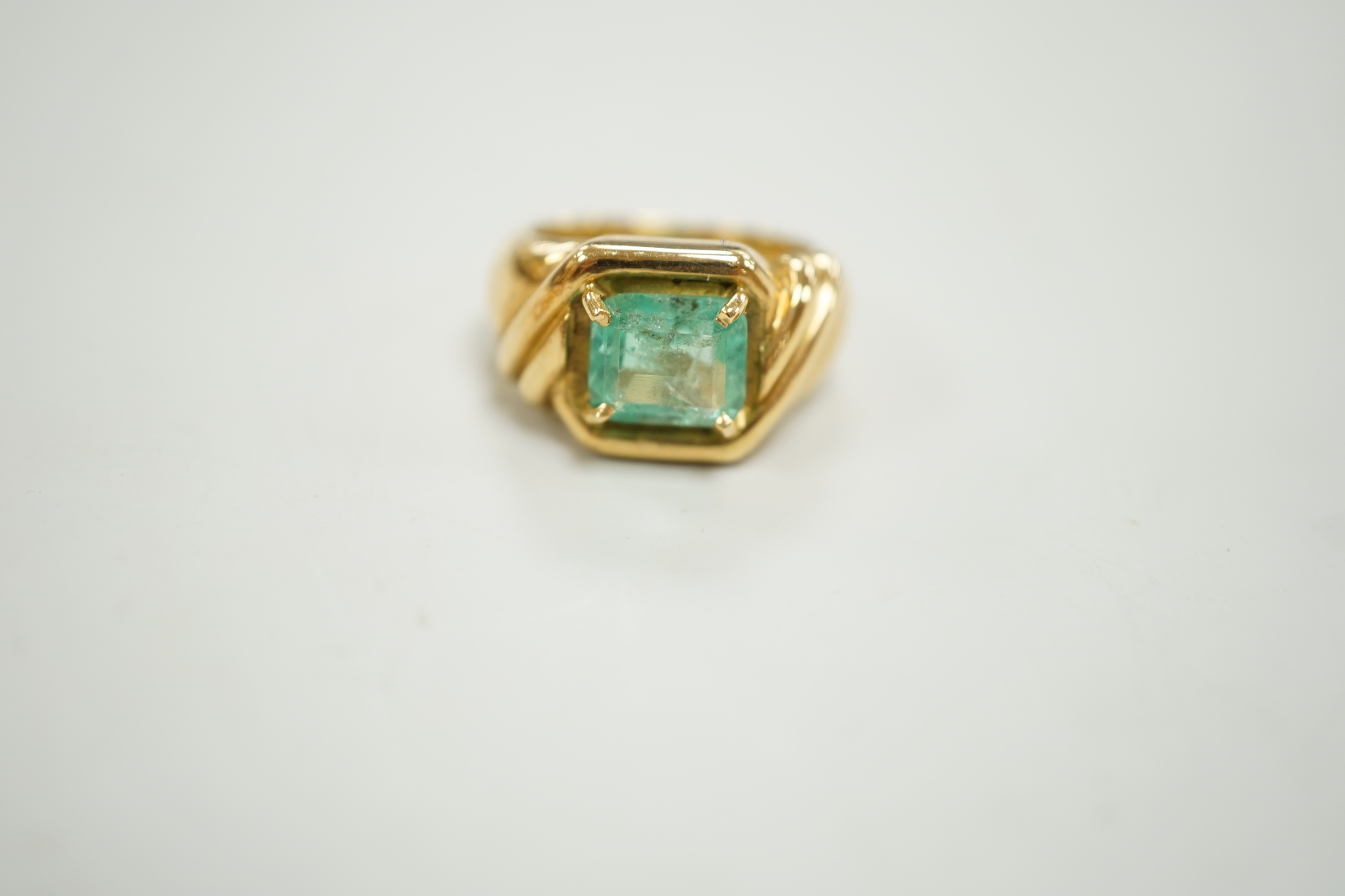 A yellow metal and single stone emerald set dress ring, with fluted shoulders, size I/J, gross weight 10.3 grams.